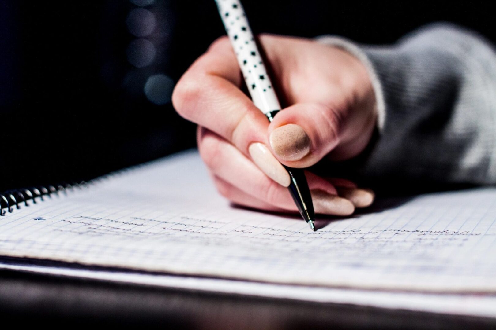 Image of a hand writing in a notebook.